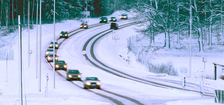 Väg med bilar i snötäckt landskap