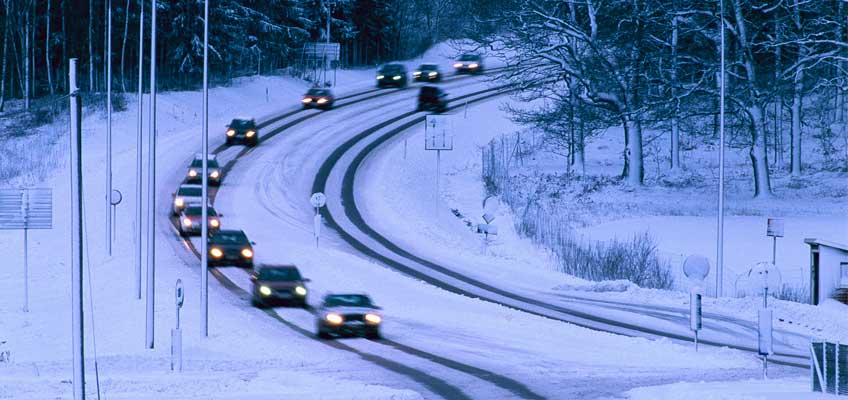 Väg med bilar i snötäckt landskap